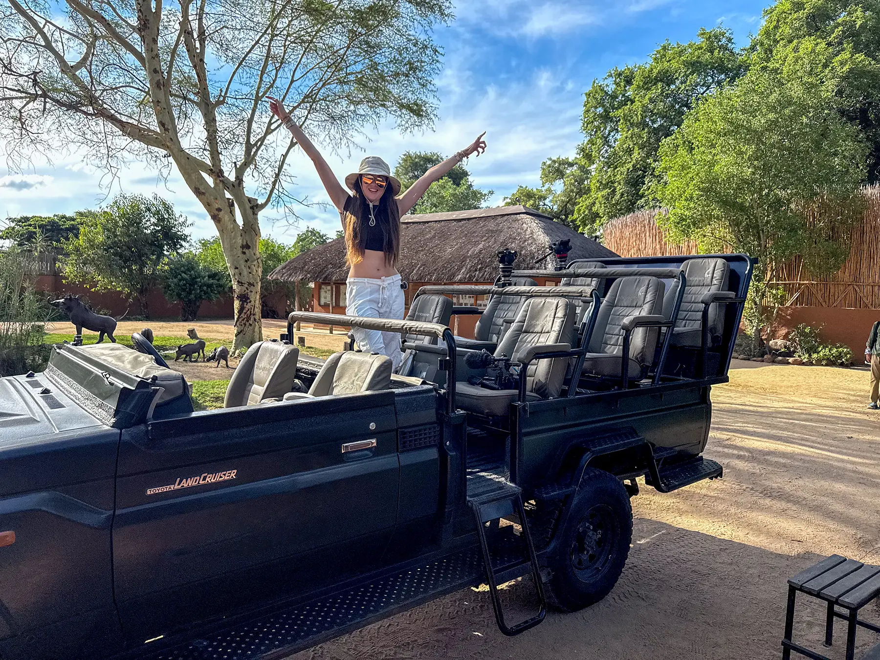 Ella McKendrick standing in a Toyota Land Cruiser on safari in MalaMala Game Reserve, South Africa
