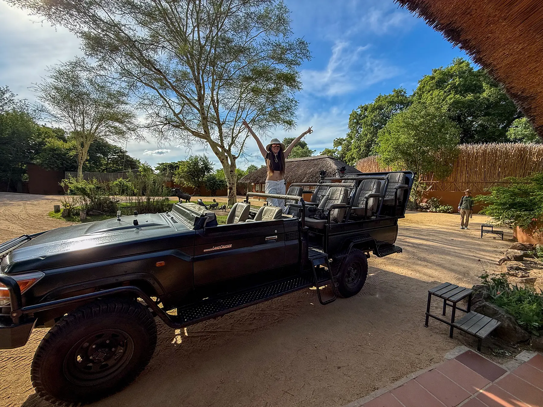 Ella McKendrick standing in an open-sided game-drive Land Cruiser on safari in MalaMala Game Reserve, South Africa