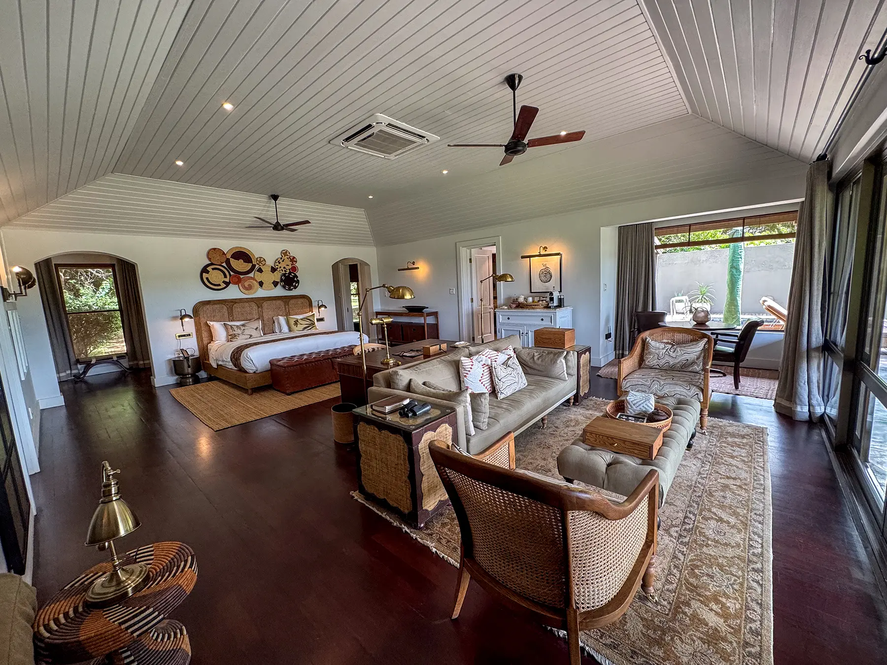 Open-plan suite with bed, seating area and desk under a gabled ceiling at Rattray's in MalaMala Game Reserve, South Africa