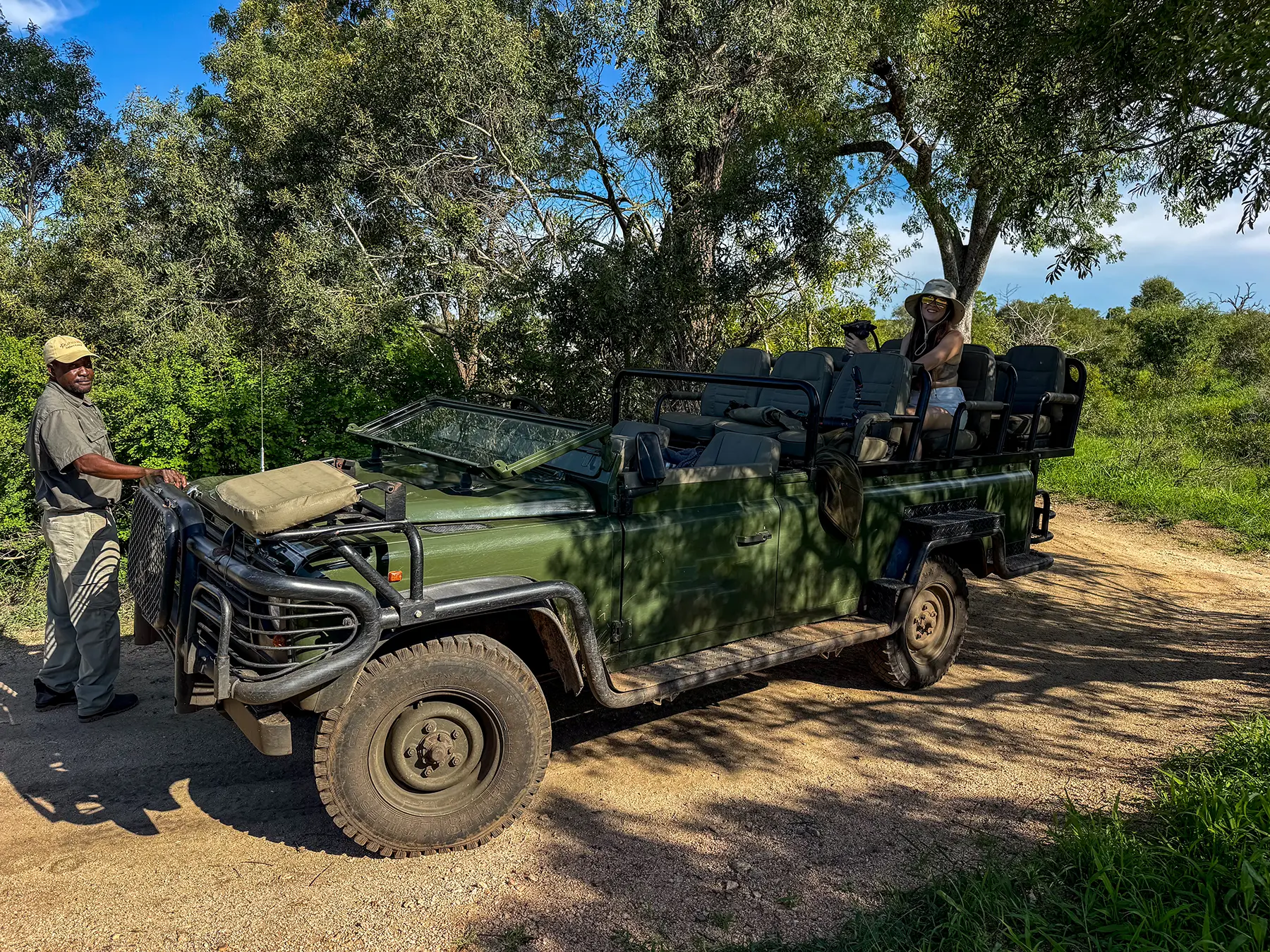 Ella McKendrick in a safari vehicle with a guide standing beside it on safari in Manyeleti Game Reserve, South Africa