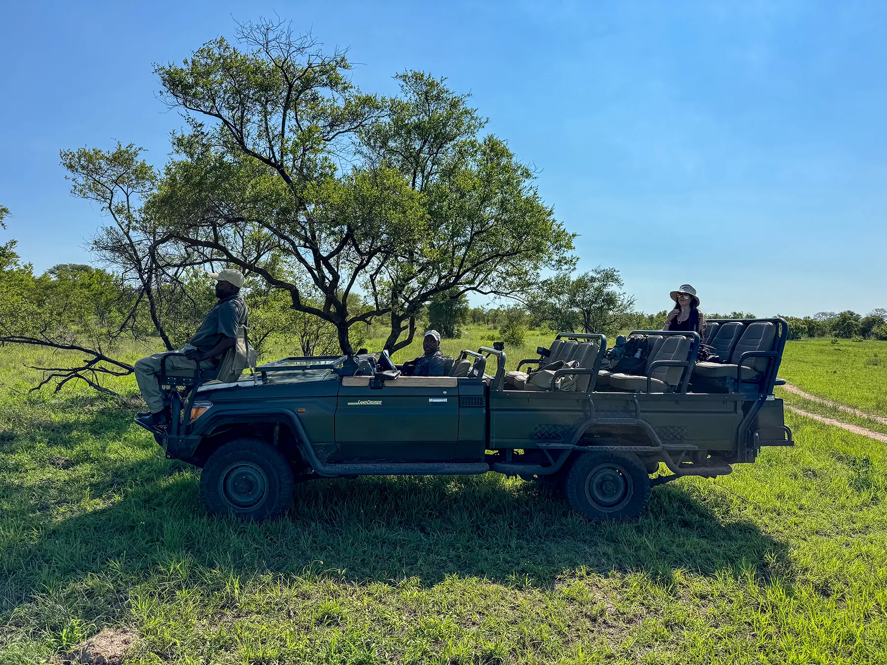 Ella McKendrick standing in a parked Land Cruiser with a safari guide on safari in Manyeleti Game Reserve, South Africa