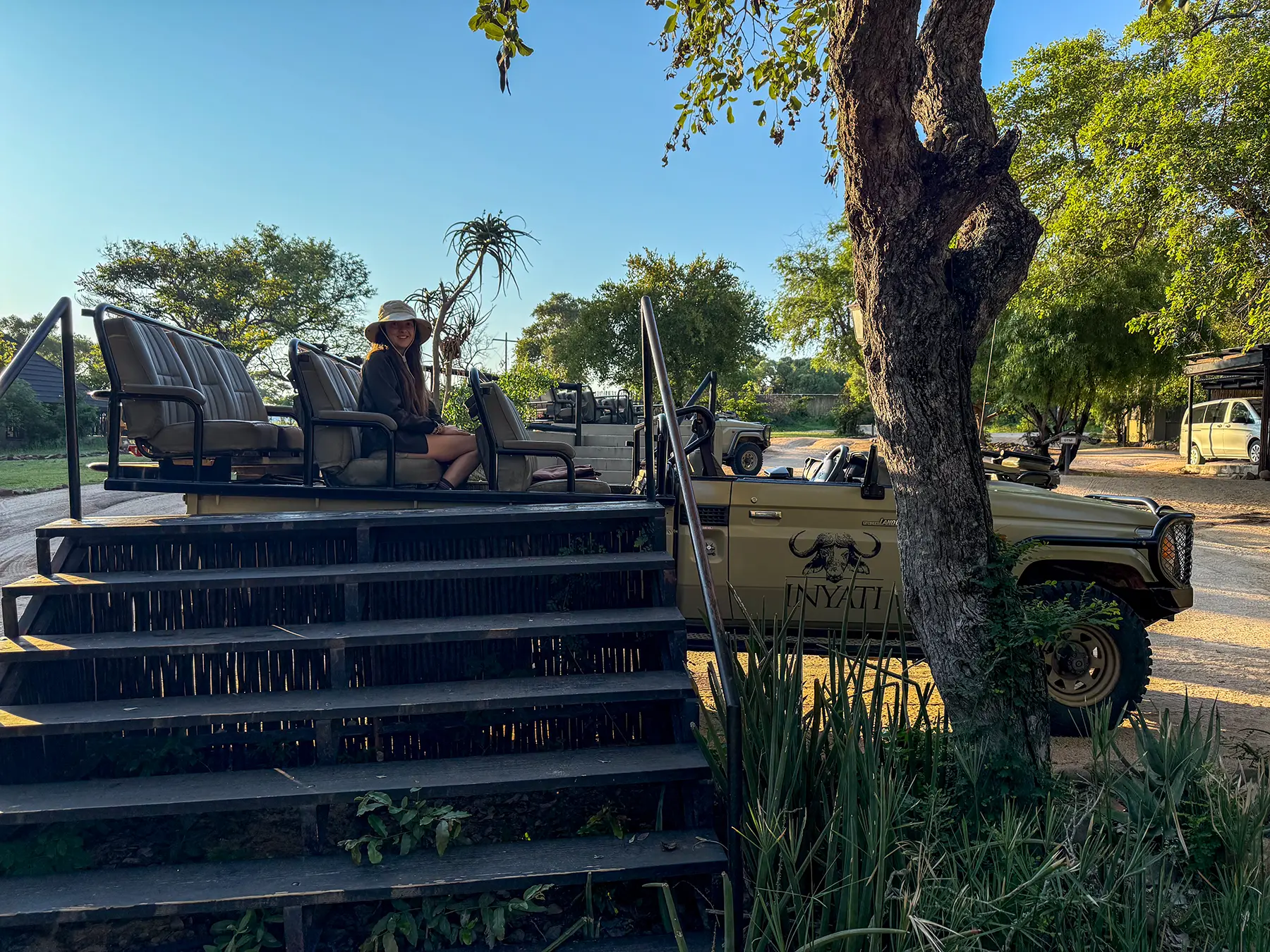 Ella McKendrick sitting in a Land Cruiser beside the boarding steps on safari in Sabi Sand Game Reserve, South Africa