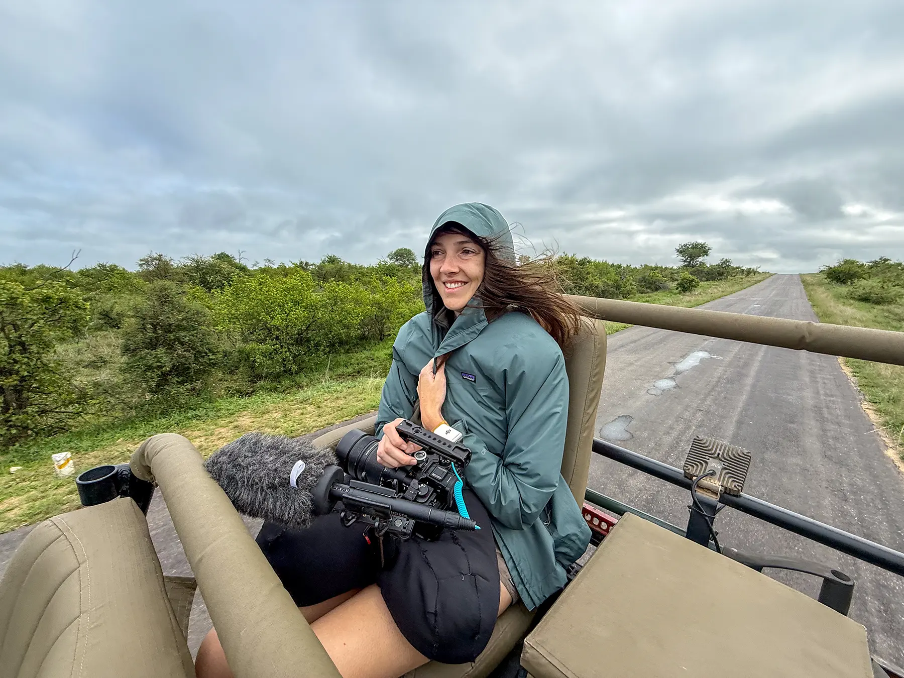 Ella McKendrick holding a camera rig with microphone in a safari truck on safari in Timbavati Private Nature Reserve, South Africa