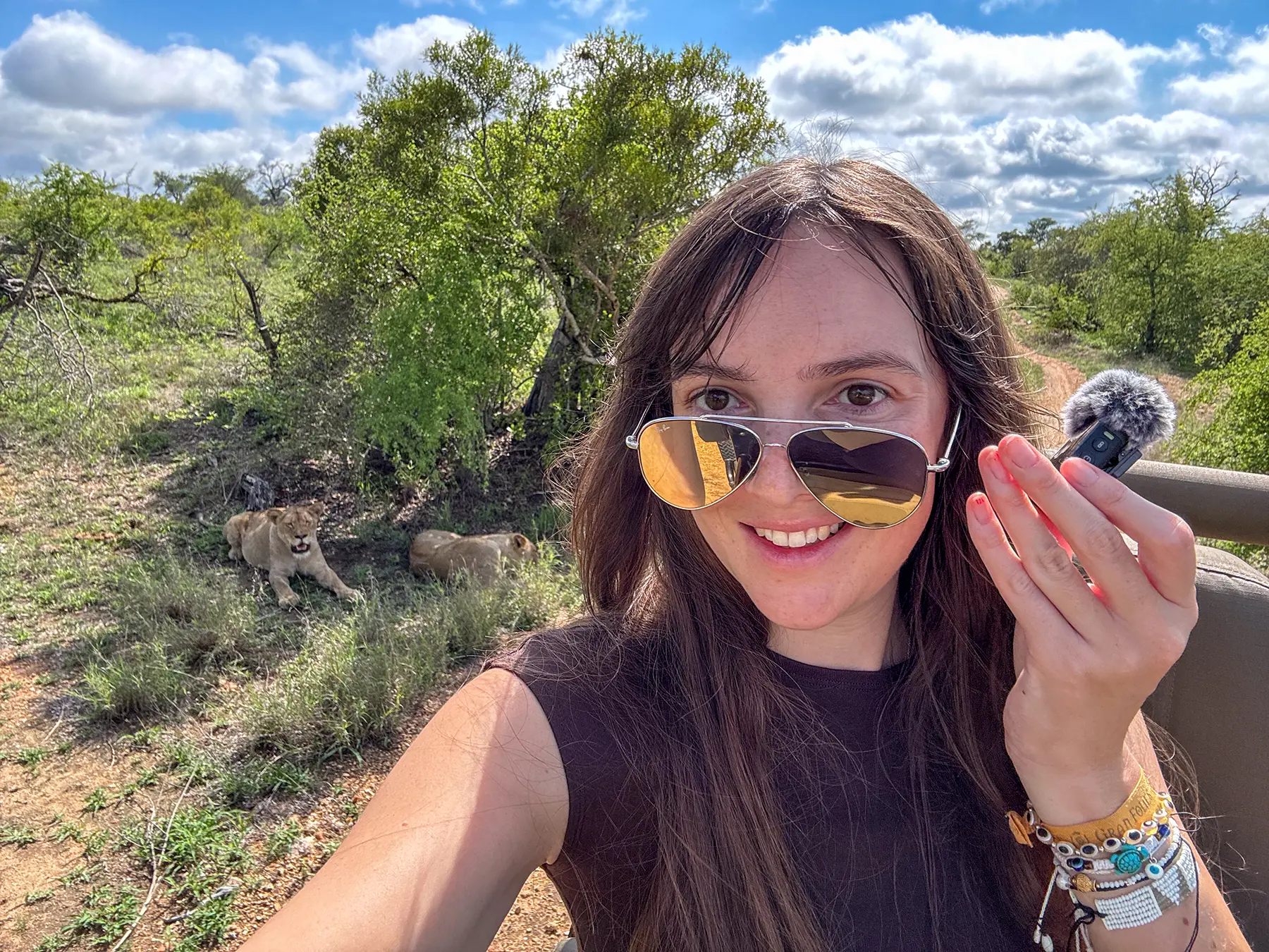 Ella McKendrick with two lionesses lying behind her on safari in Timbavati Private Nature Reserve, South Africa