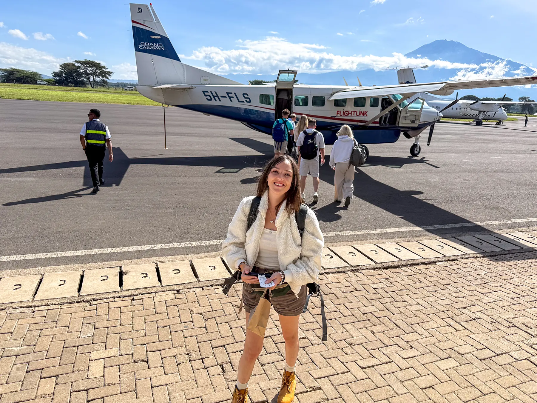 Ella McKendrick near the apron as passengers board a Cessna Caravan below Mount Meru at Arusha Airport in Arusha, Tanzania